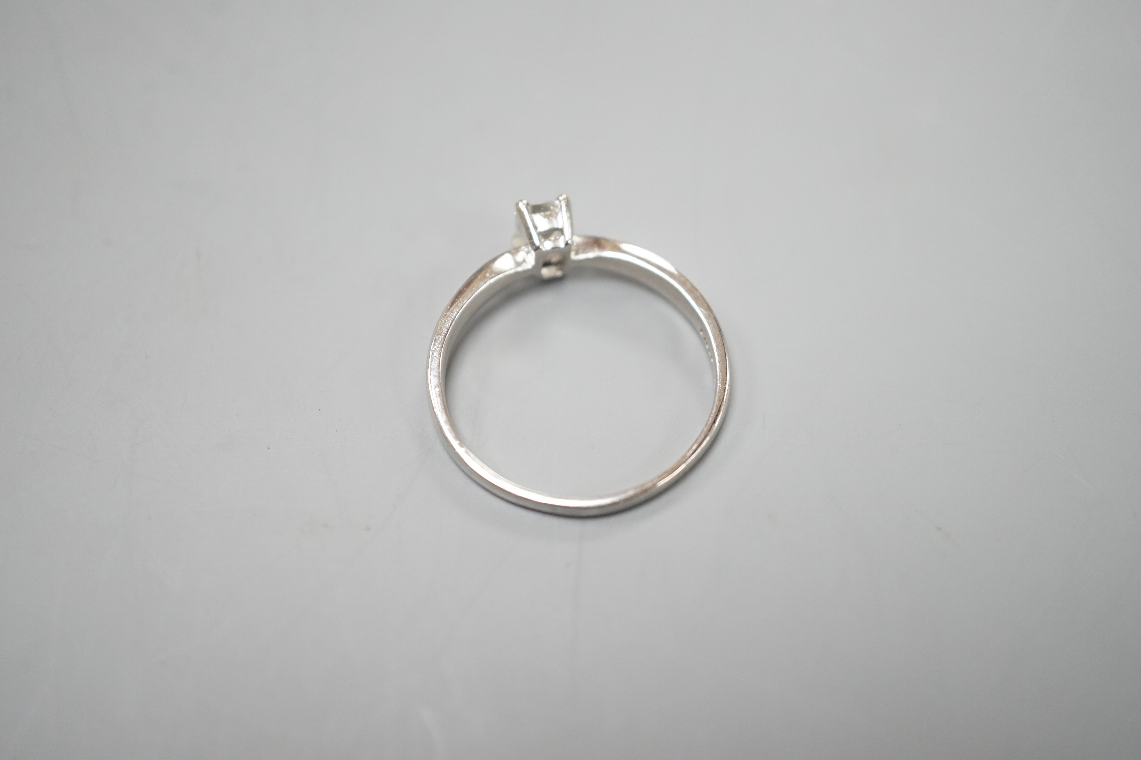 A modern platinum and solitaire emerald cut diamond set ring, size P/Q, gross weight 3.2 grams